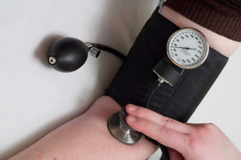 Blood pressure cuff and stethoscope being used to check blood pressure